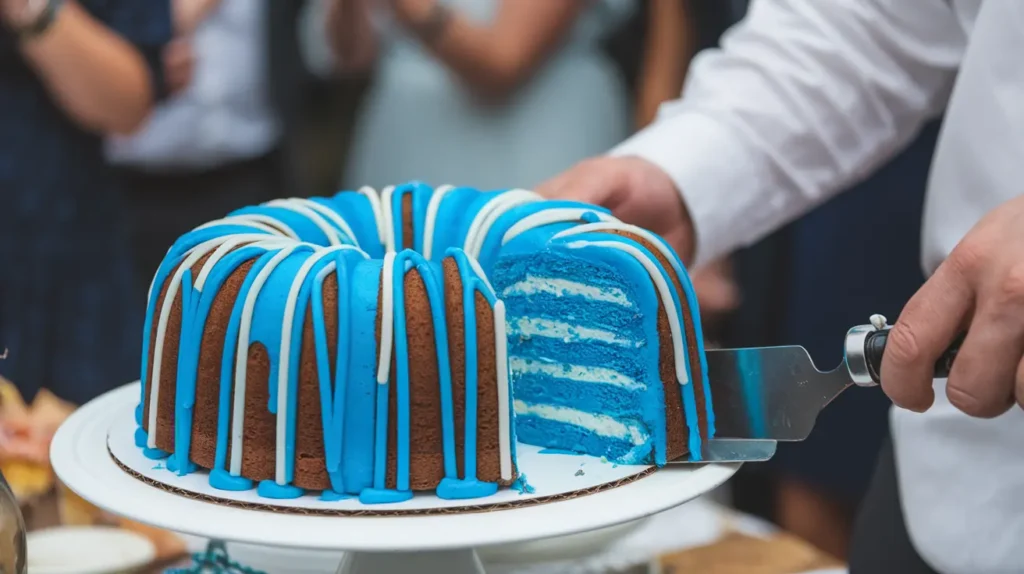 Nothing Bundt Cake being sliced to reveal blue frosting, surrounded by clapping guests.